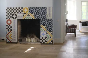 A fireplace framed with patterned tiles